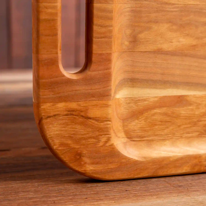 Cherry Barbecue Board with handles. Close  up of rounded corner of board.